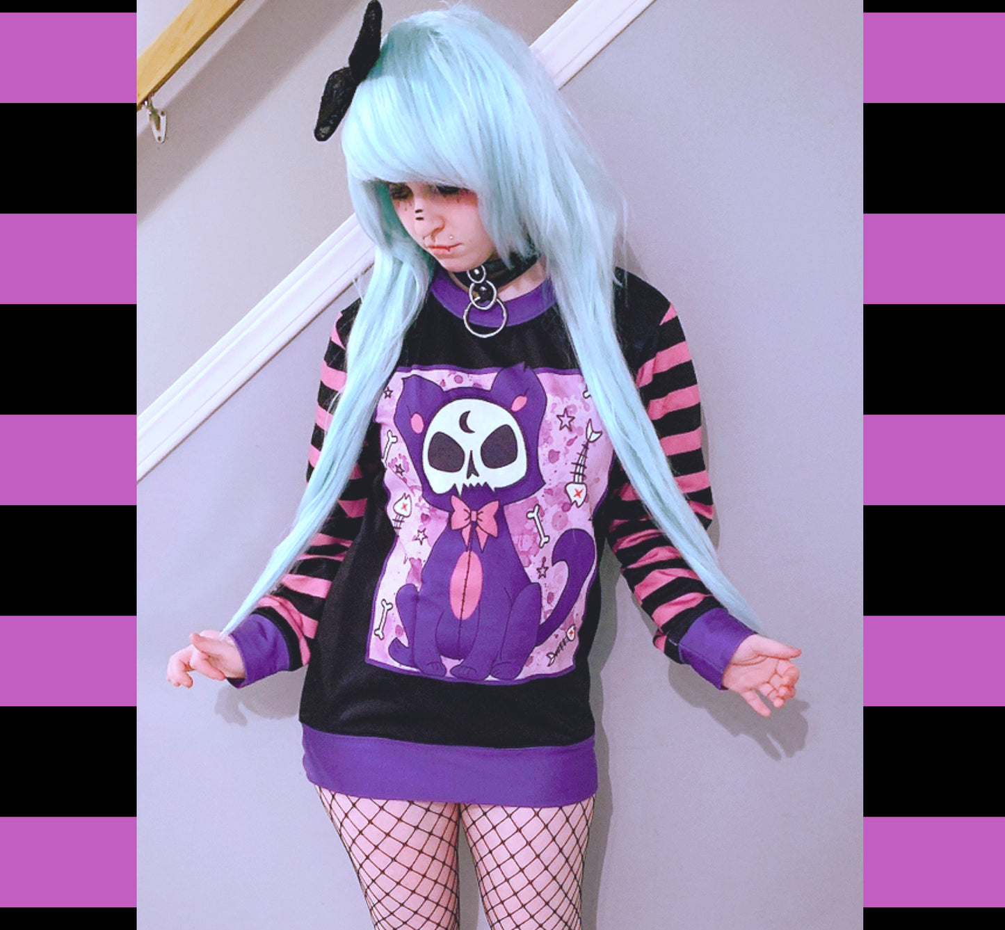 Young girl wearing a pastel goth sweatshirt with cute cat design.