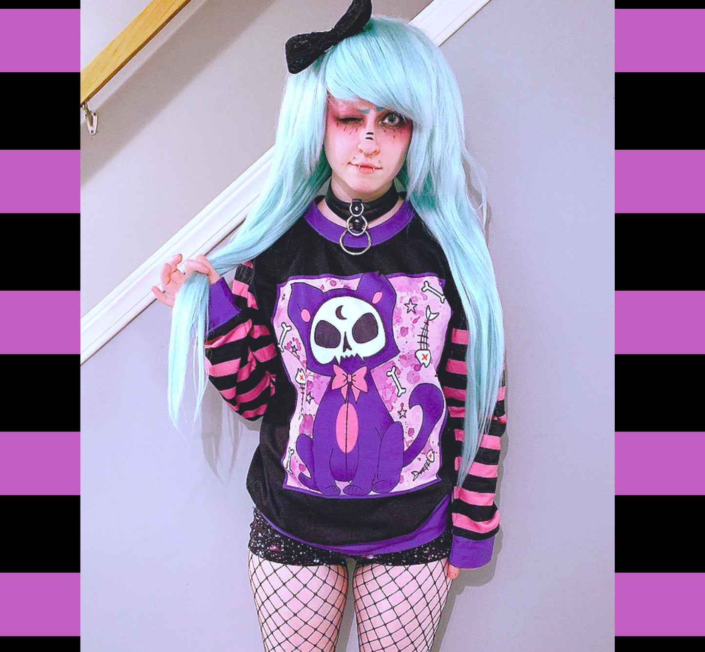 Young girl wearing a pastel goth sweatshirt with cute cat design.