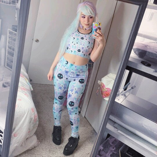 Young girl wearing pastel goth cute and creepy leggings with soft colors