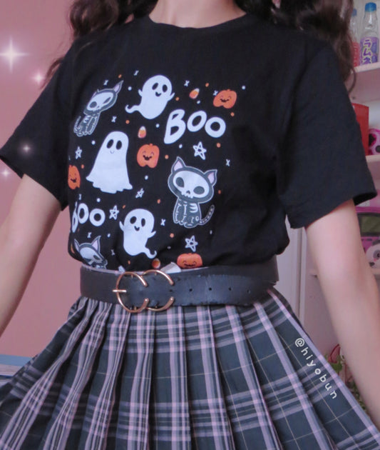 Young girl wearing a pastel goth Halloween t-shirt with pumpkin ghosts and boo desing.