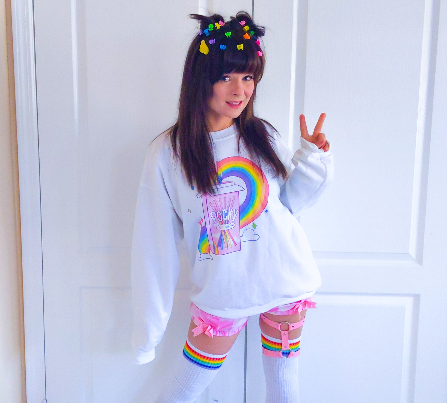 Young girl wearing a pastel kawaii pride sweatshirt with a cute print.