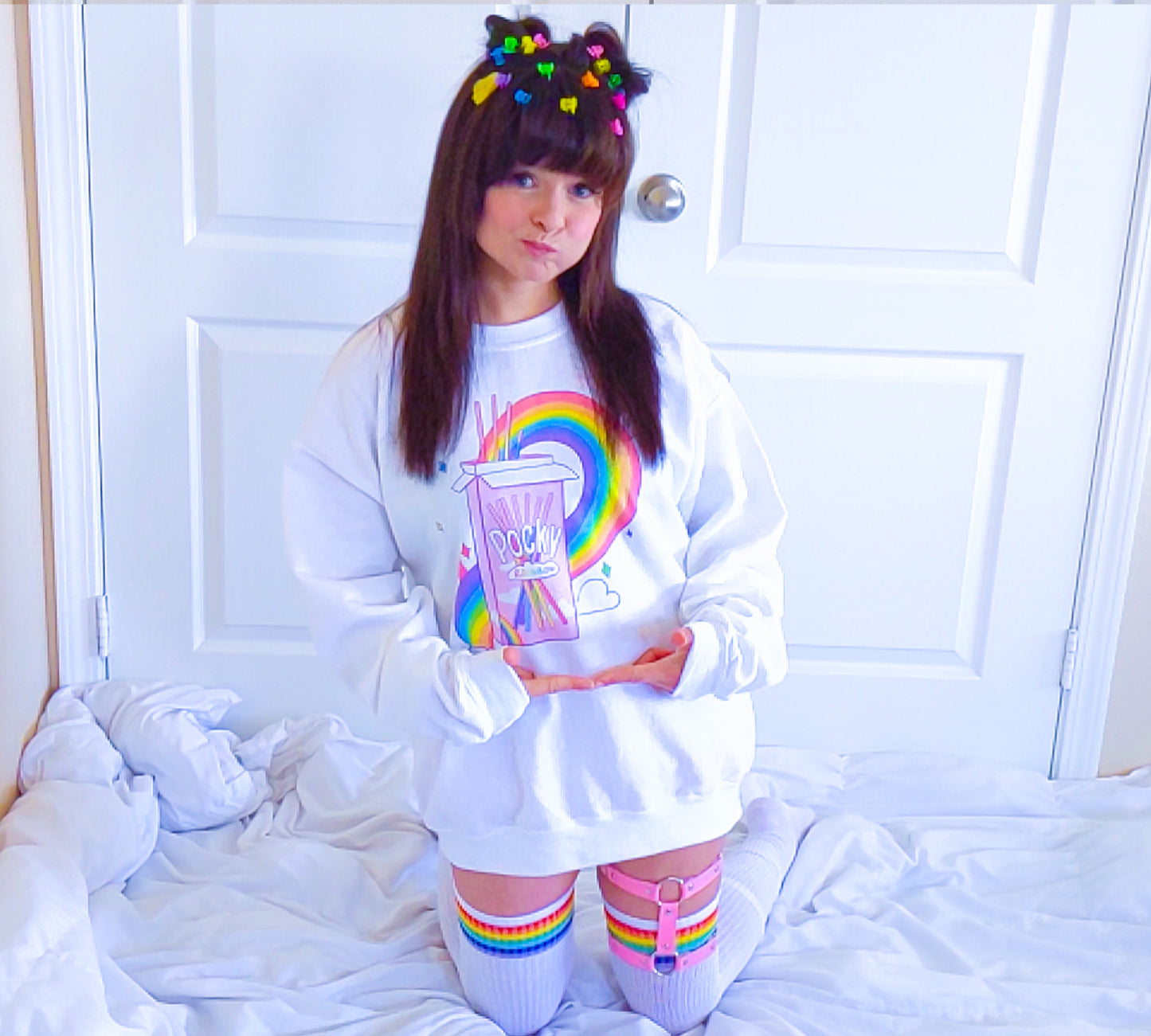 Young girl wearing a pastel kawaii pride sweatshirt with a cute print.