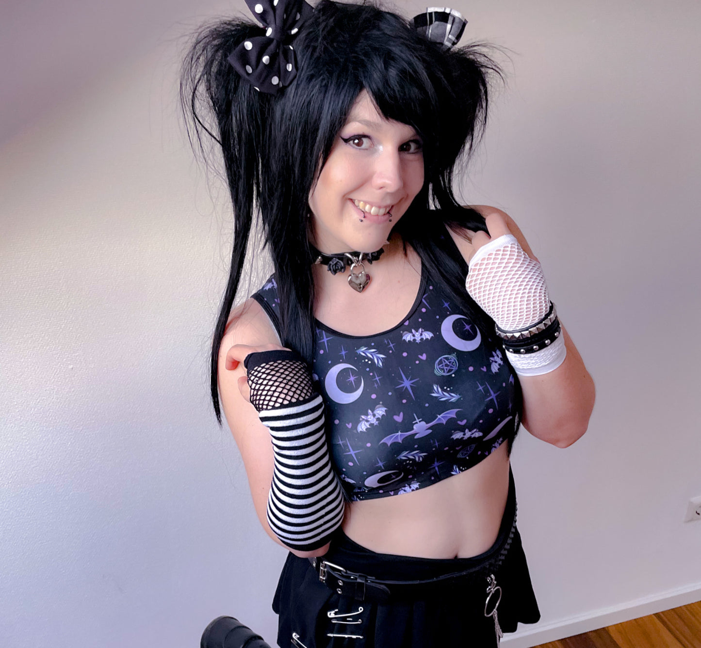 Young girl wearing a pastel goth crop top with creepy cute bat design