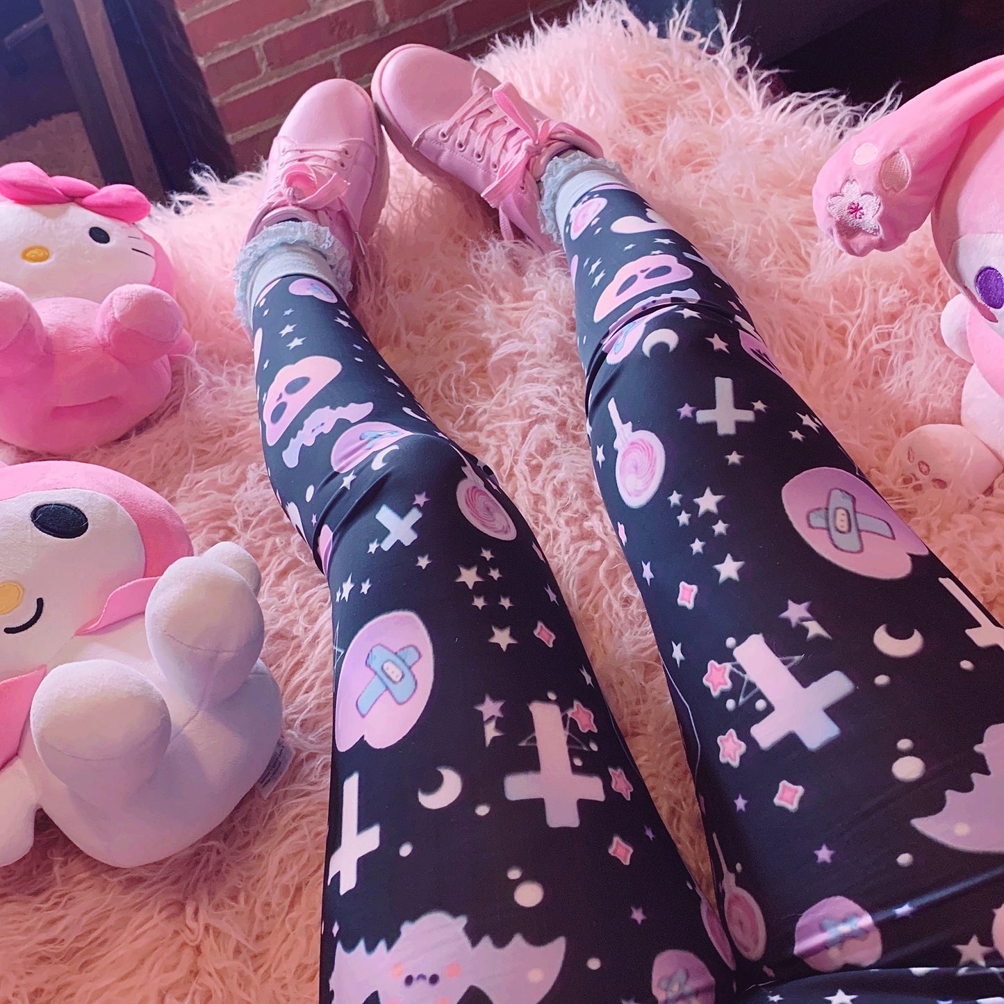 Young girl wearing a pastel goth leggings with creepy skull and bat design.