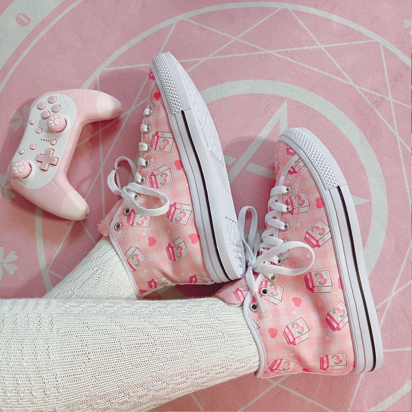 Pair of cute, stylish shoes neatly arranged on a pink background