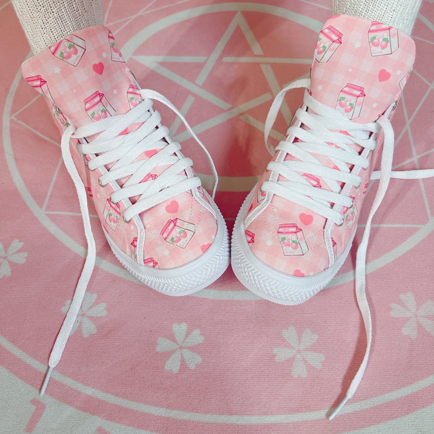 Pair of cute, stylish shoes neatly arranged on a pink background