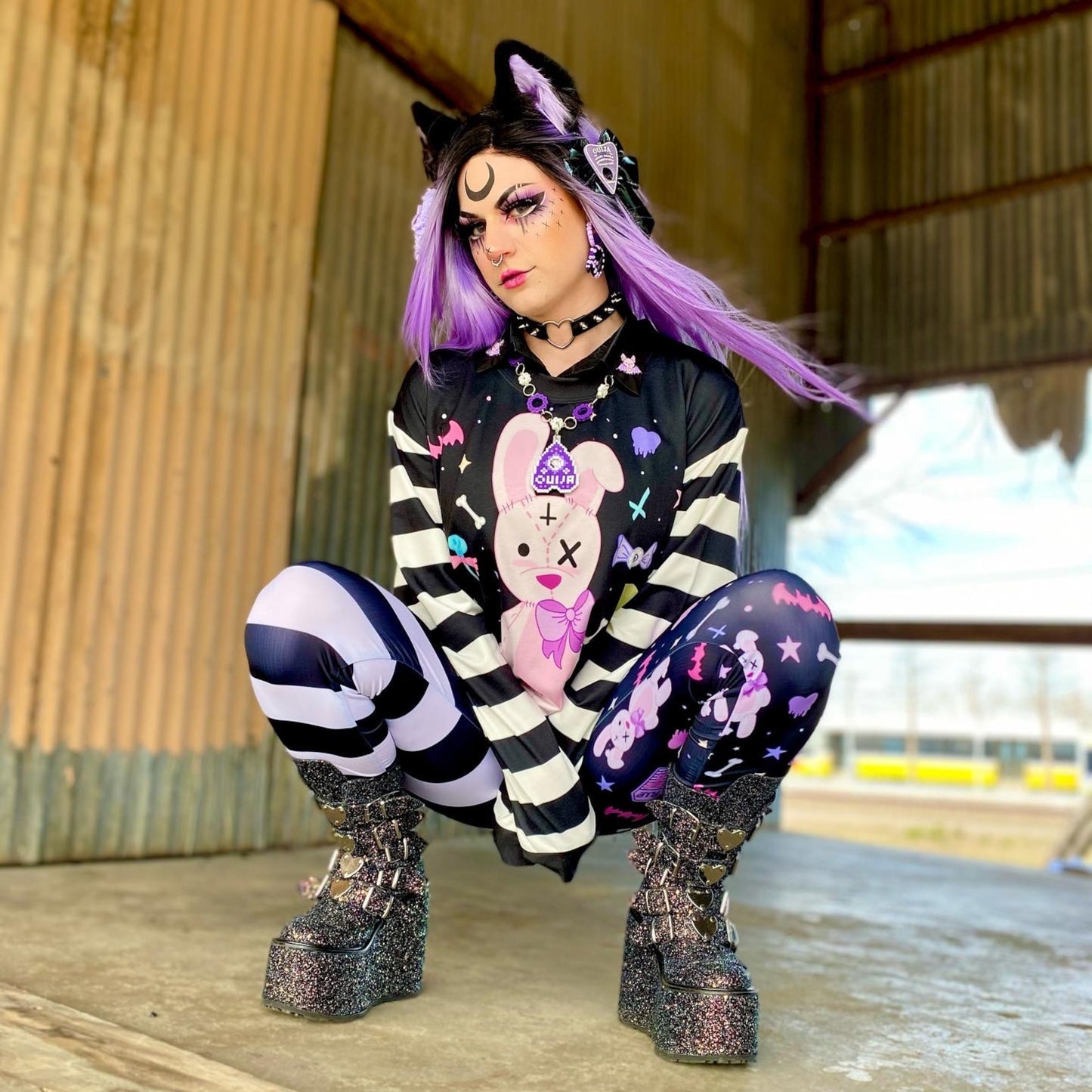 Teen girl dressed in kawaii goth fashion with a spooky-cute graphic sweatshirt