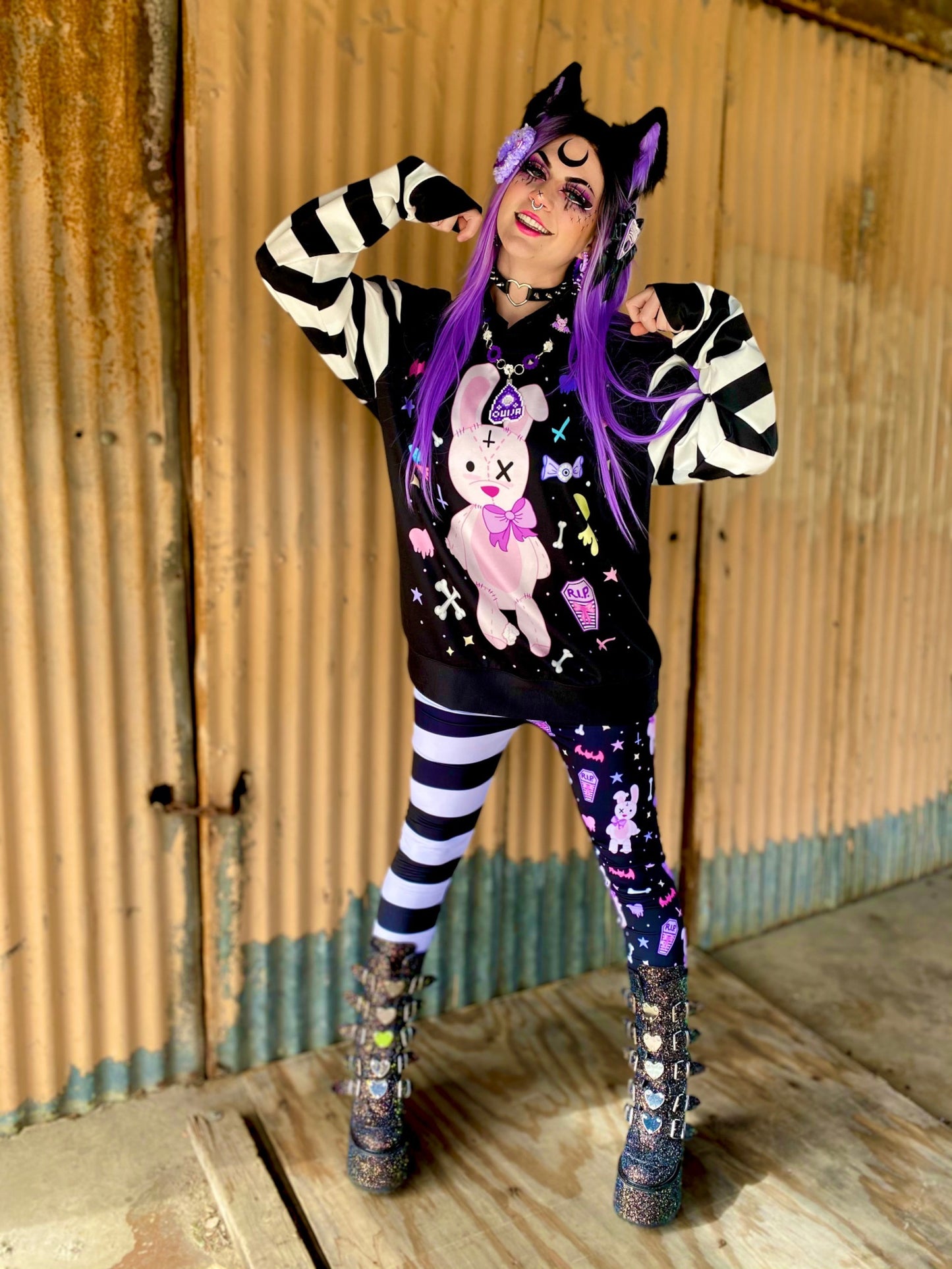 Teen girl dressed in kawaii goth fashion with a spooky-cute graphic sweatshirt