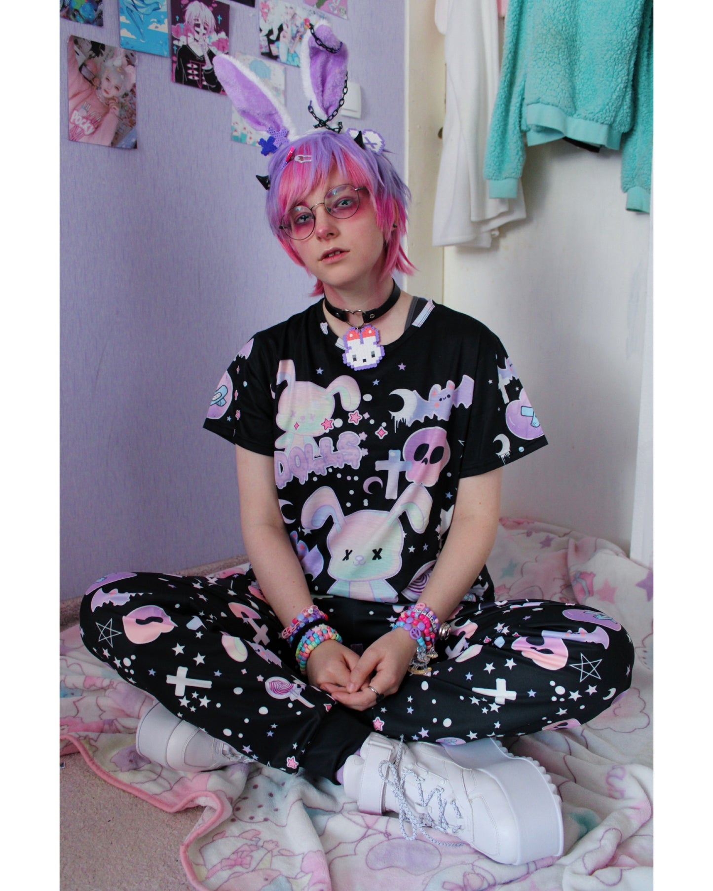Model wearing a pastel goth joggers with black and purple colours and creepy cute bats and skulls design