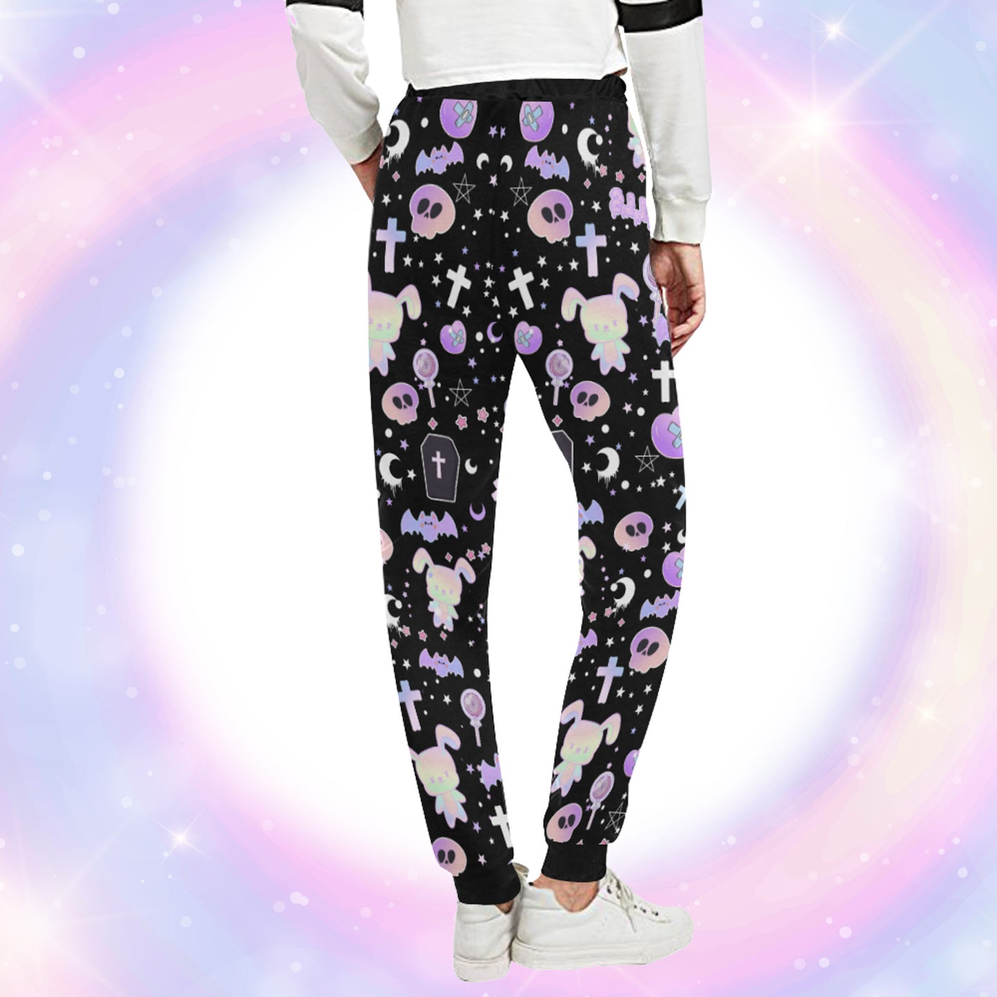 Model wearing a pastel goth joggers with black and purple colours and creepy cute bats and skulls design on pastel background