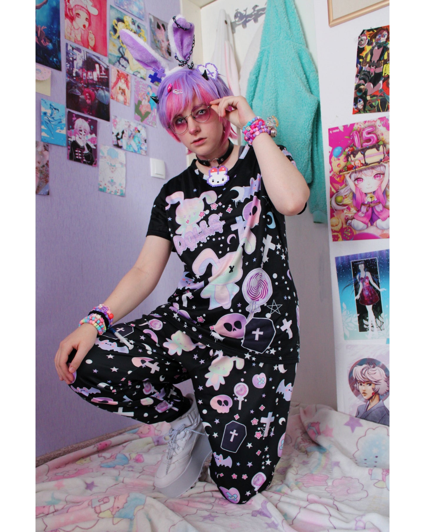Model wearing a pastel goth joggers with black and purple colours and creepy cute bats and skulls design