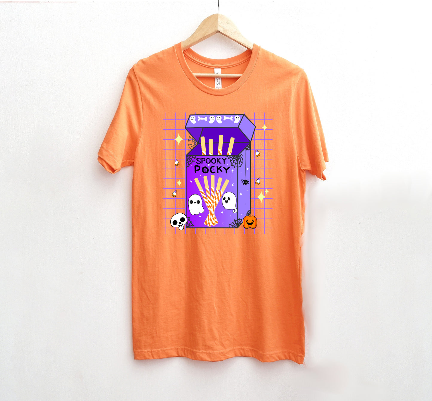 Orange t-shirt with a halloween purple candy box graphic on a white background