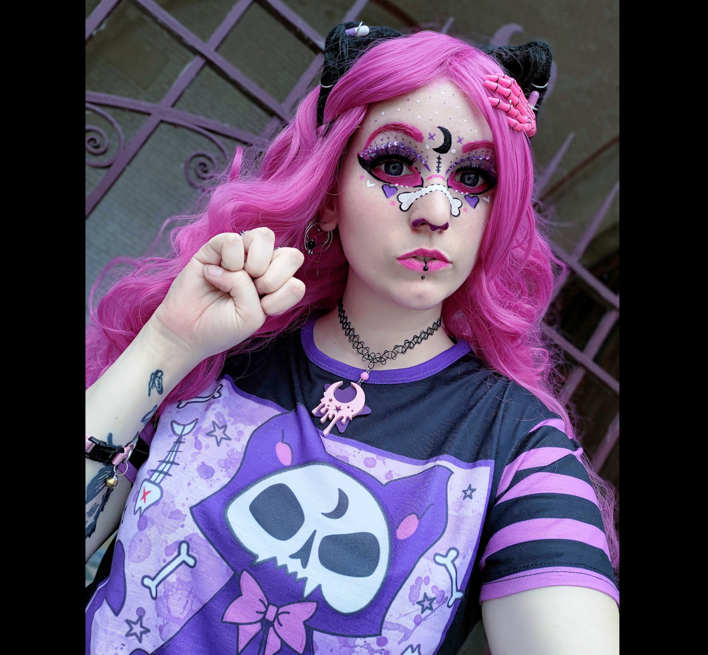 Girl modeling a pastel goth t-shirt with cat skull design