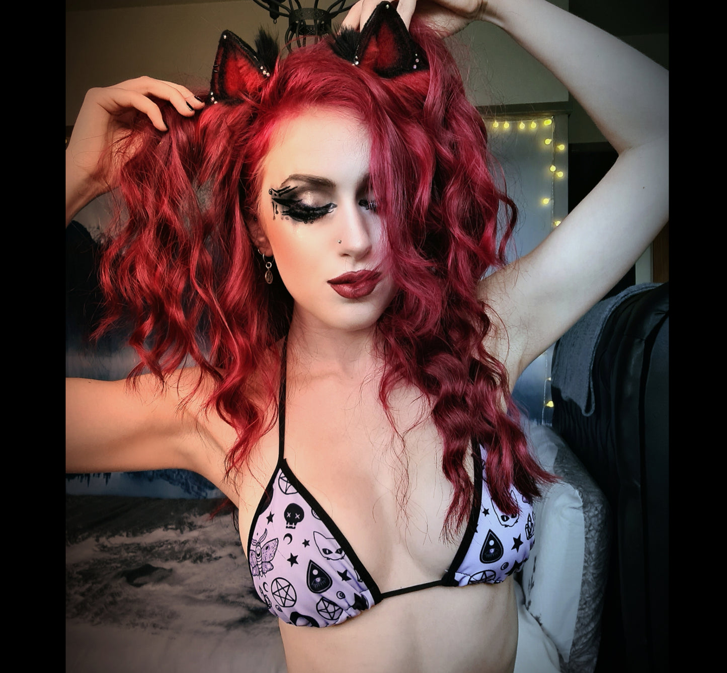 Girl modelling a pastel goth bikini with spooky designs
