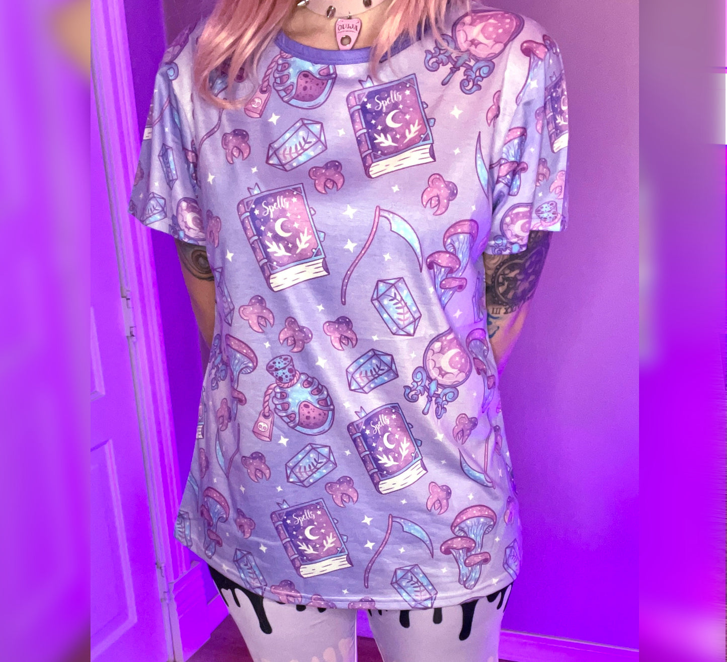 Teen girl dressed in pastel goth fashion with a spooky-cute graphic tee