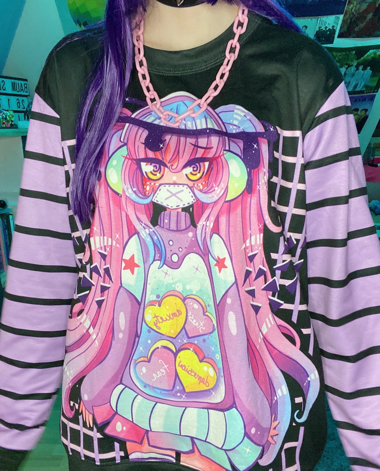 Young girl wearing a pastel goth sweatshirt with soft colors and creepy design.