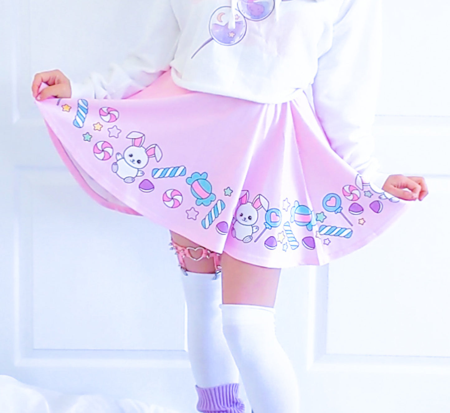 Happy girl dressed in a kawaii t-shirt styled with a pastel skirt, standing in natural light