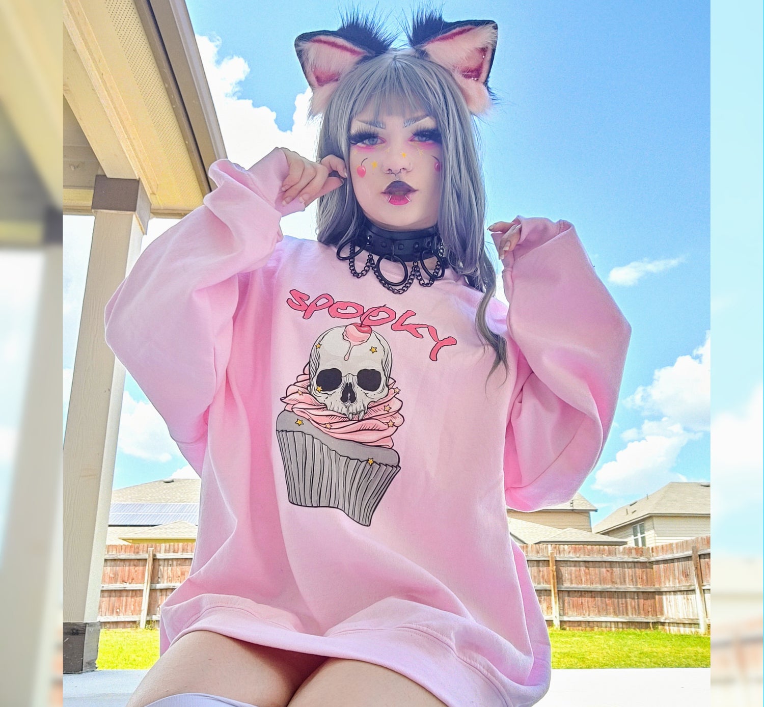 Girl modelling a Kawaii Goth Halloween sweatshirt with spooky skull design