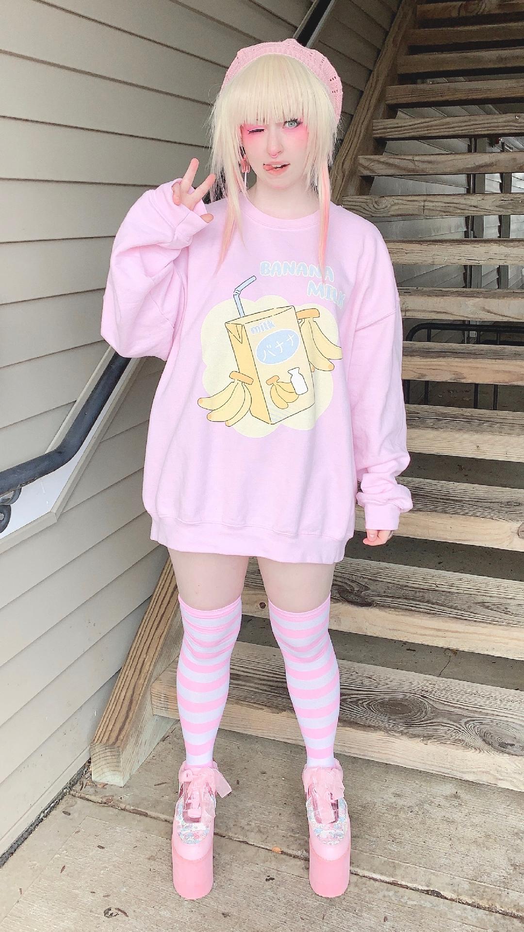 Youthful model wearing a cute kawaii sweatshirt with pastel accessories