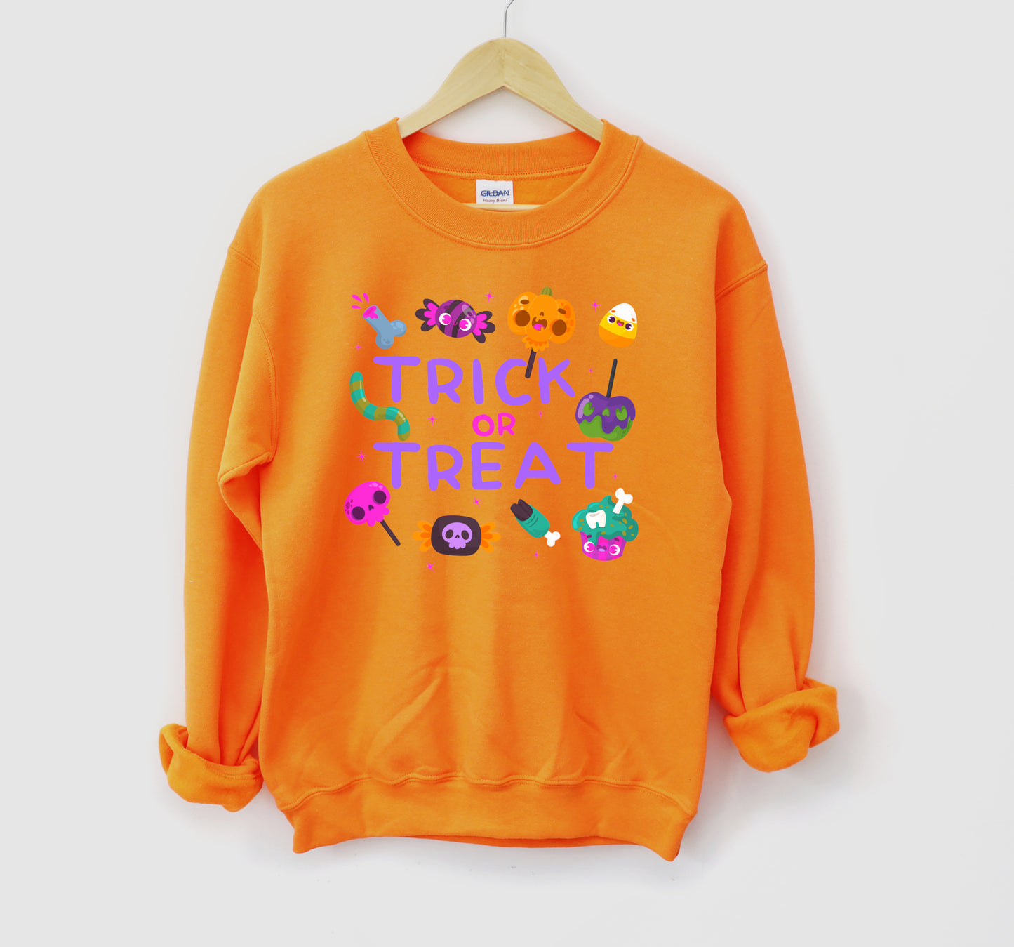 Orange sweatshirt with 'Trick or Treat' text and Halloween-themed graphics on a white background