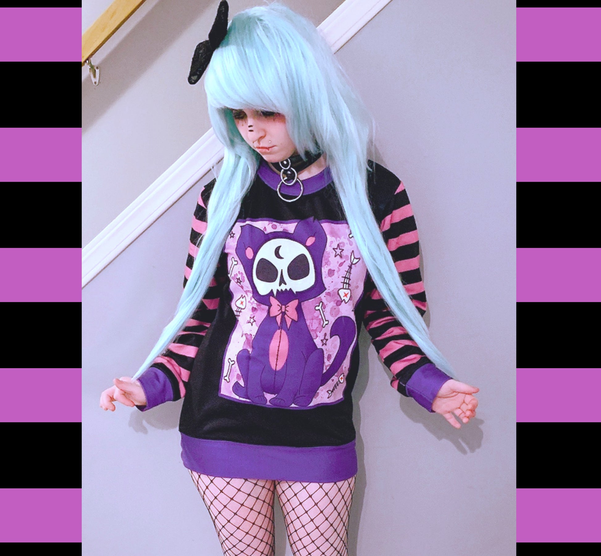 Young girl wearing a pastel goth sweatshirt with cute cat  design.