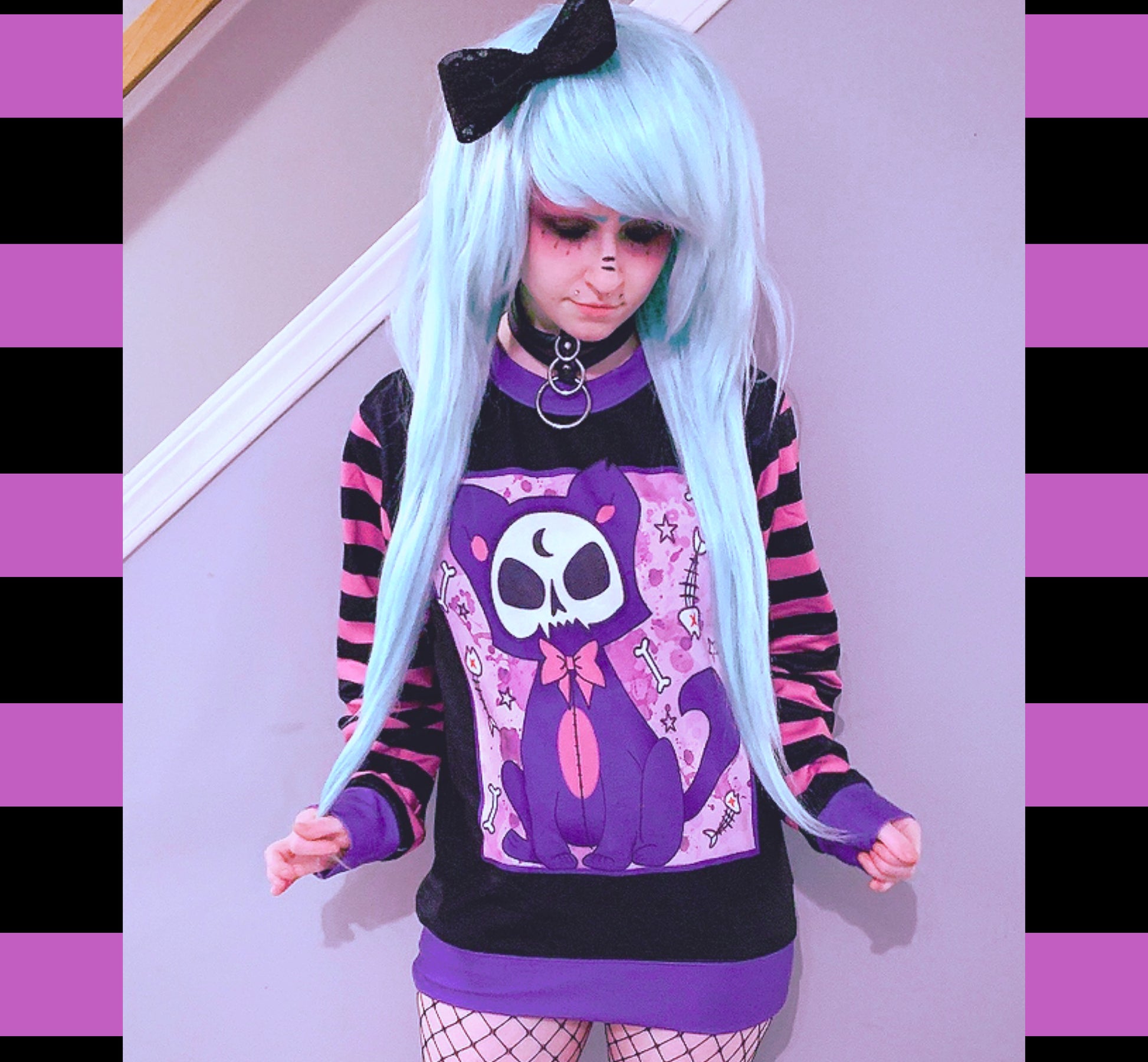  Young girl wearing a pastel goth sweatshirt with cute cat  design.