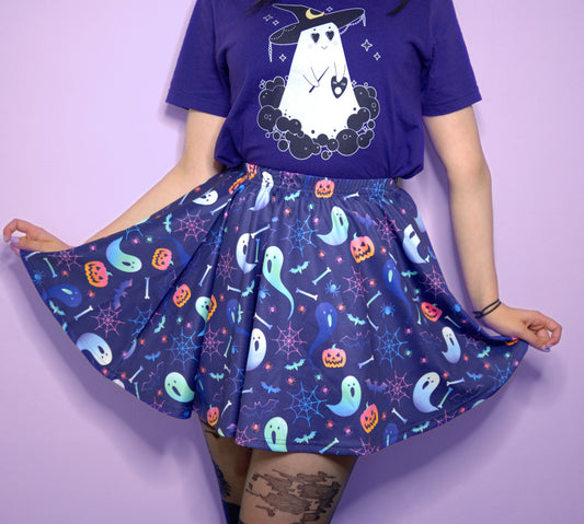 Young girl wearing a pastel goth Halloween skirt with pumpkin ghosts desing.