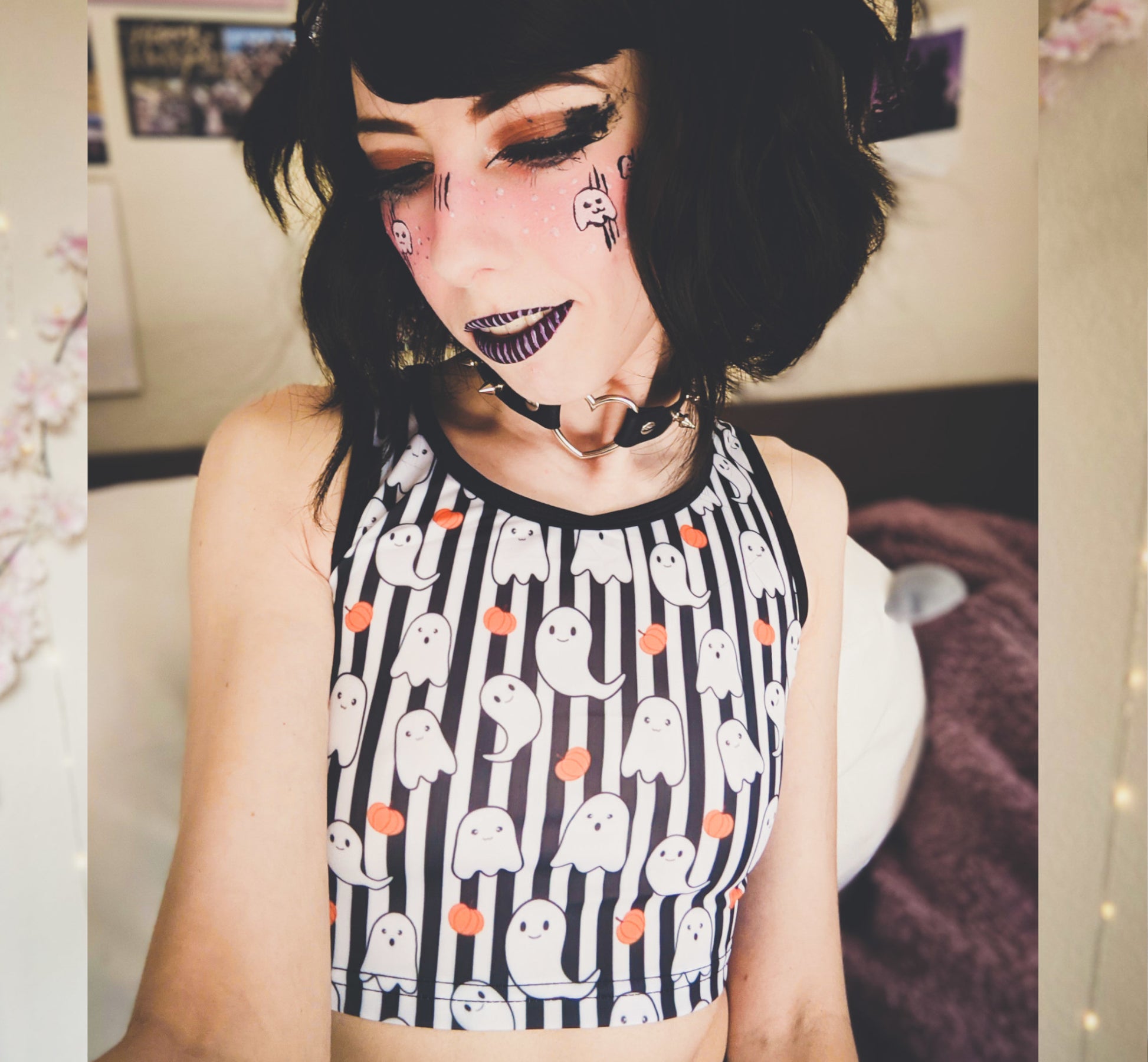 Young girl wearing a pastel goth Halloween crop top with pumpkin ghosts desing.