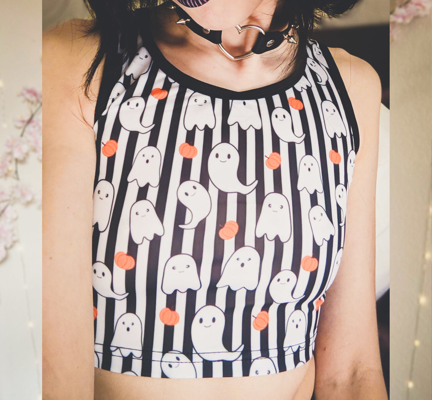 Young girl wearing a pastel goth Halloween crop top with pumpkin ghosts desing.