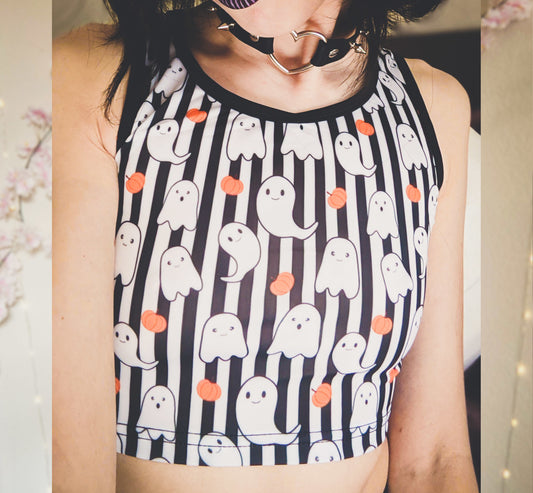 Young girl wearing a pastel goth Halloween crop top with pumpkin ghosts desing.