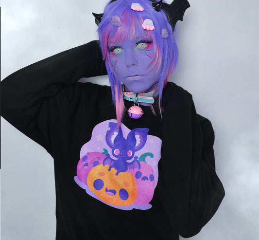 Girl modelling a Kawaii Cute Halloween sweatshirt with bat and pumpkin design