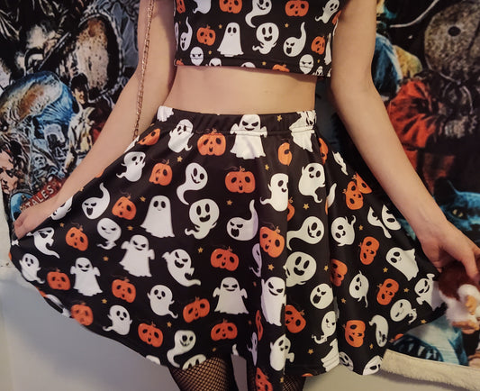 Young girl wearing a pastel goth Halloween skirt with pumpkin ghosts desing.
