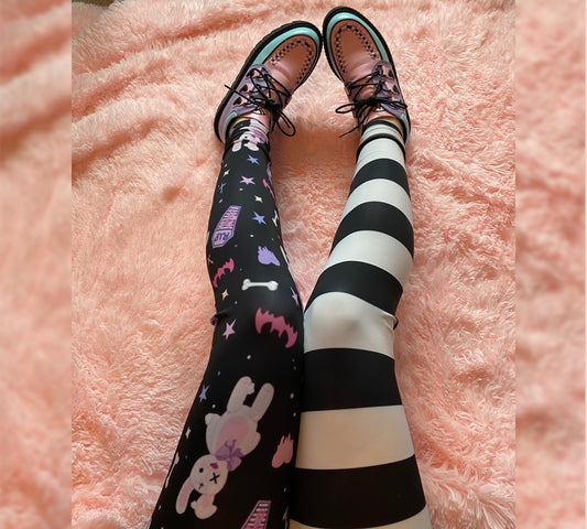 Young girl wearing kawaii goth  bunny cute and creepy leggings on a pink background