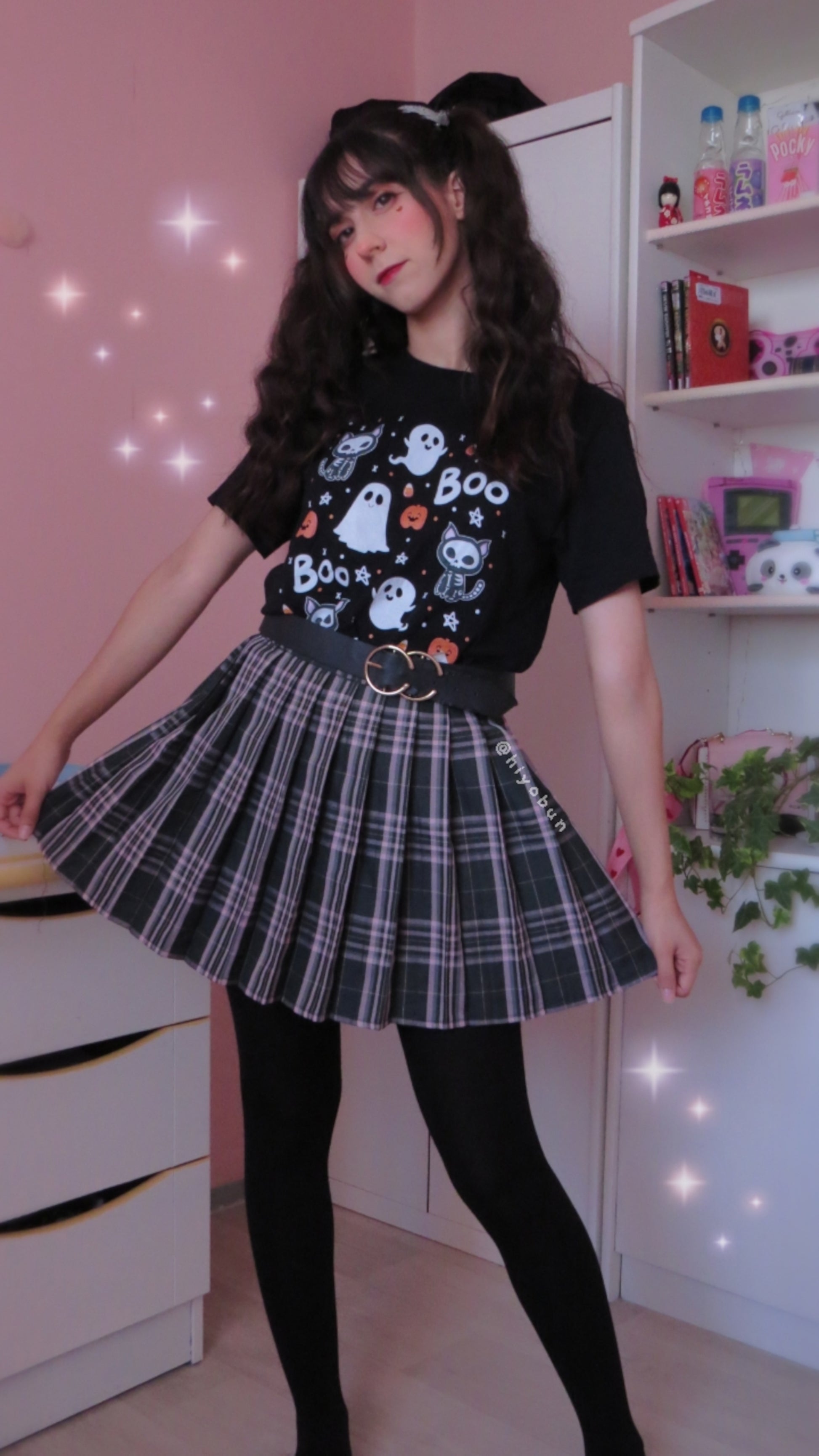 Young girl wearing a pastel goth Halloween t-shirt with pumpkin ghosts and boo desing.