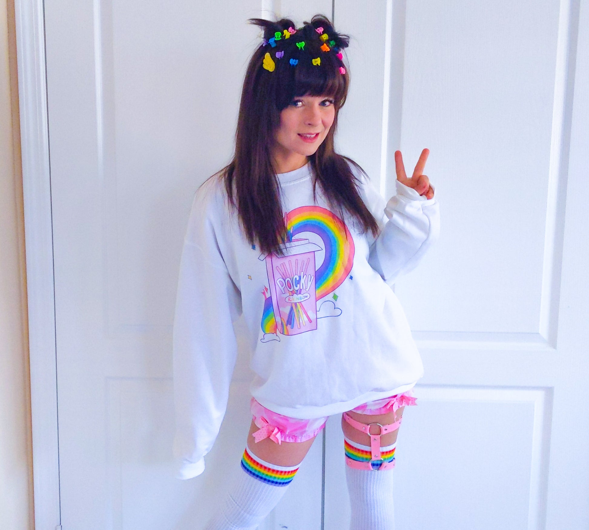 Young girl wearing a pastel kawaii pride sweatshirt with a cute print.