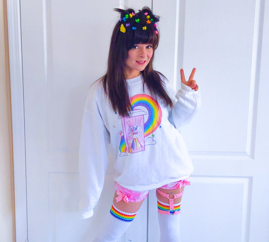 Young girl wearing a pastel kawaii pride sweatshirt with a cute print.