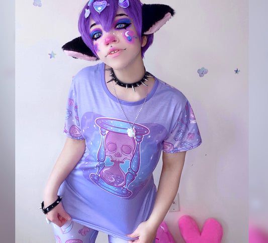 model wearing a pastel goth t-shirt with soft colours and spooky skull hourglass  design.