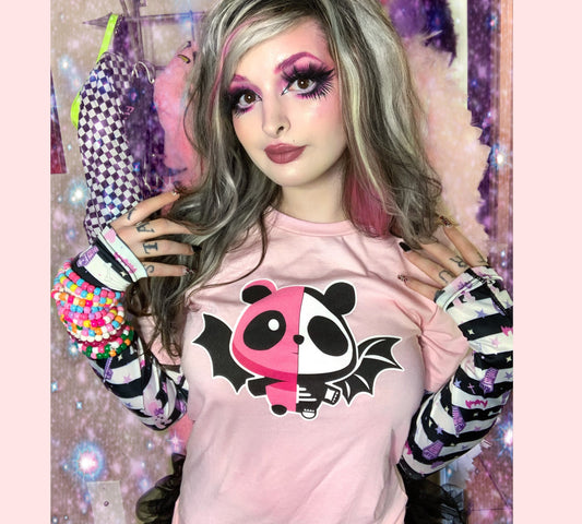 model wearing a pastel goth t-shirt with soft colours and spooky pink panda bat purple design.