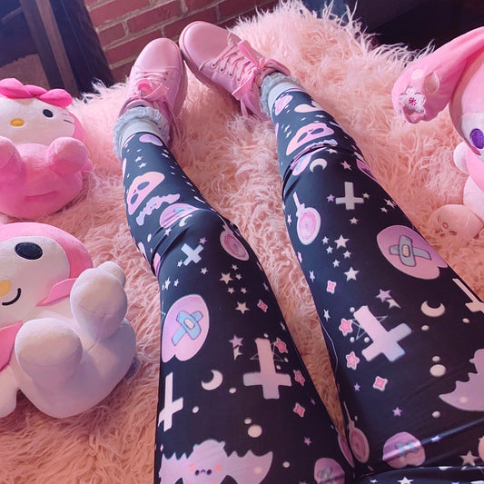 Young girl wearing a pastel goth leggings with creepy skull and bat design.
