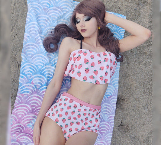 Model wearing a Yume Kawaii Strawberry High Waisted Flounce Bikini Set on patterned towel