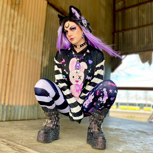 Teen girl dressed in  kawaii goth fashion with a spooky-cute graphic sweatshirt