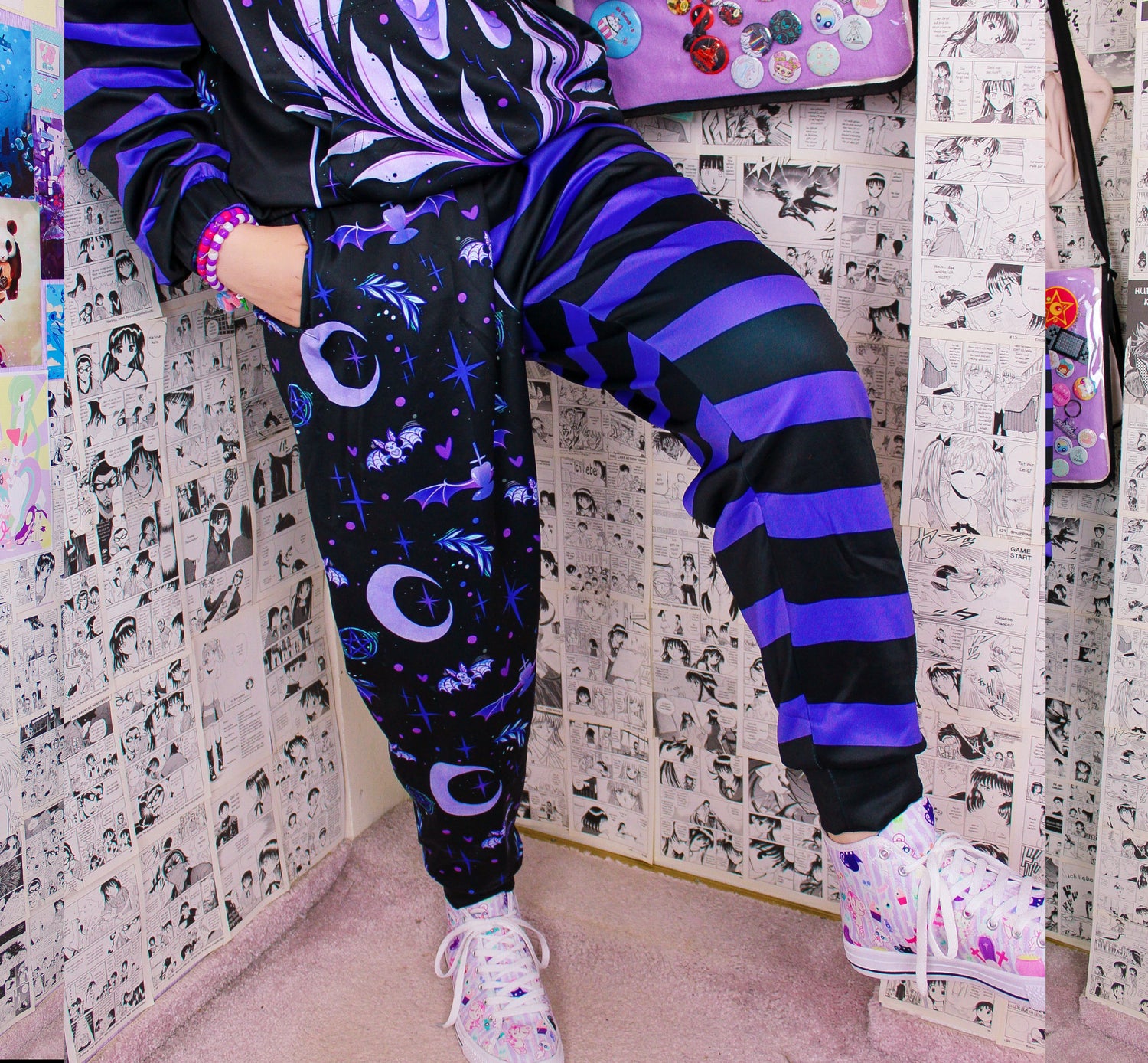Model wearing a pastel goth joggers with black and purple colors and creepy cute bat and moon design