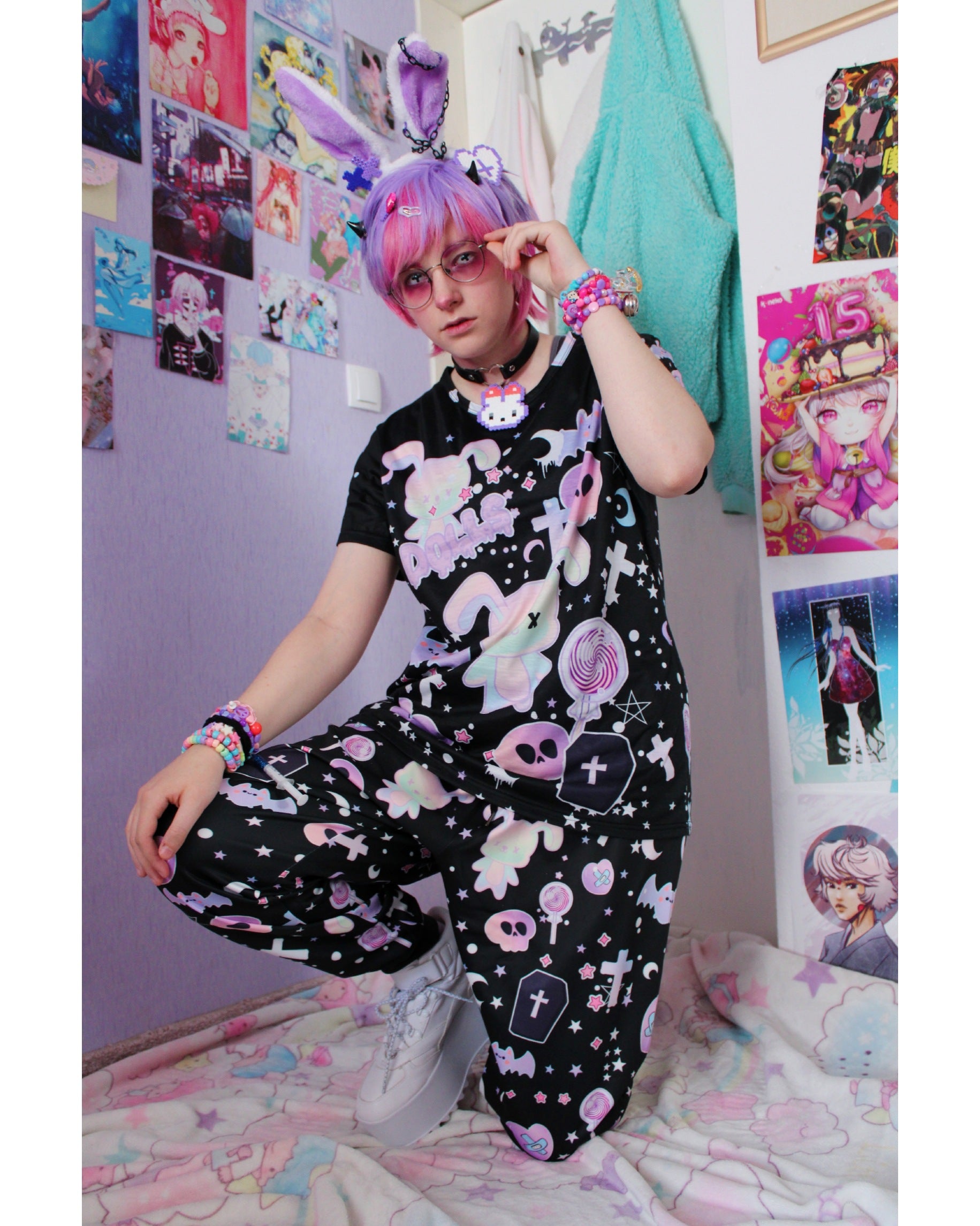 Model wearing a pastel goth joggers with black and purple colours and creepy cute bats and skulls design