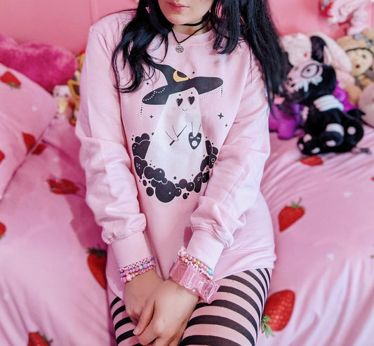 Girl modelling a pastel goth Halloween cute sweatshirt with ghost designs in pink 