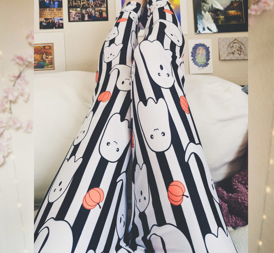 Black and white striped blanket with cartoon ghost design draped over a couch.