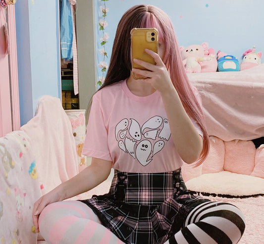 Girl wearing a cute Halloween t-shirt with pink hair taking a mirror selfie in a room with colorful decor.