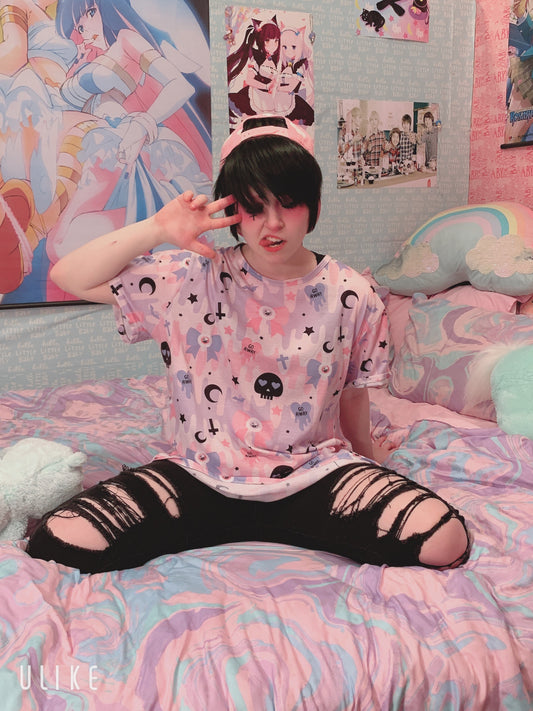 Young girl wearing a pastel goth t-shirt with soft colors and creepy cute skull design.