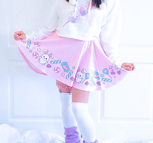 Happy girl dressed in a kawaii t-shirt styled with a pastel skirt, standing in natural light