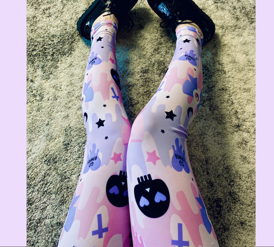 Young girl wearing a pastel goth leggings with soft colours and creepy skull design.