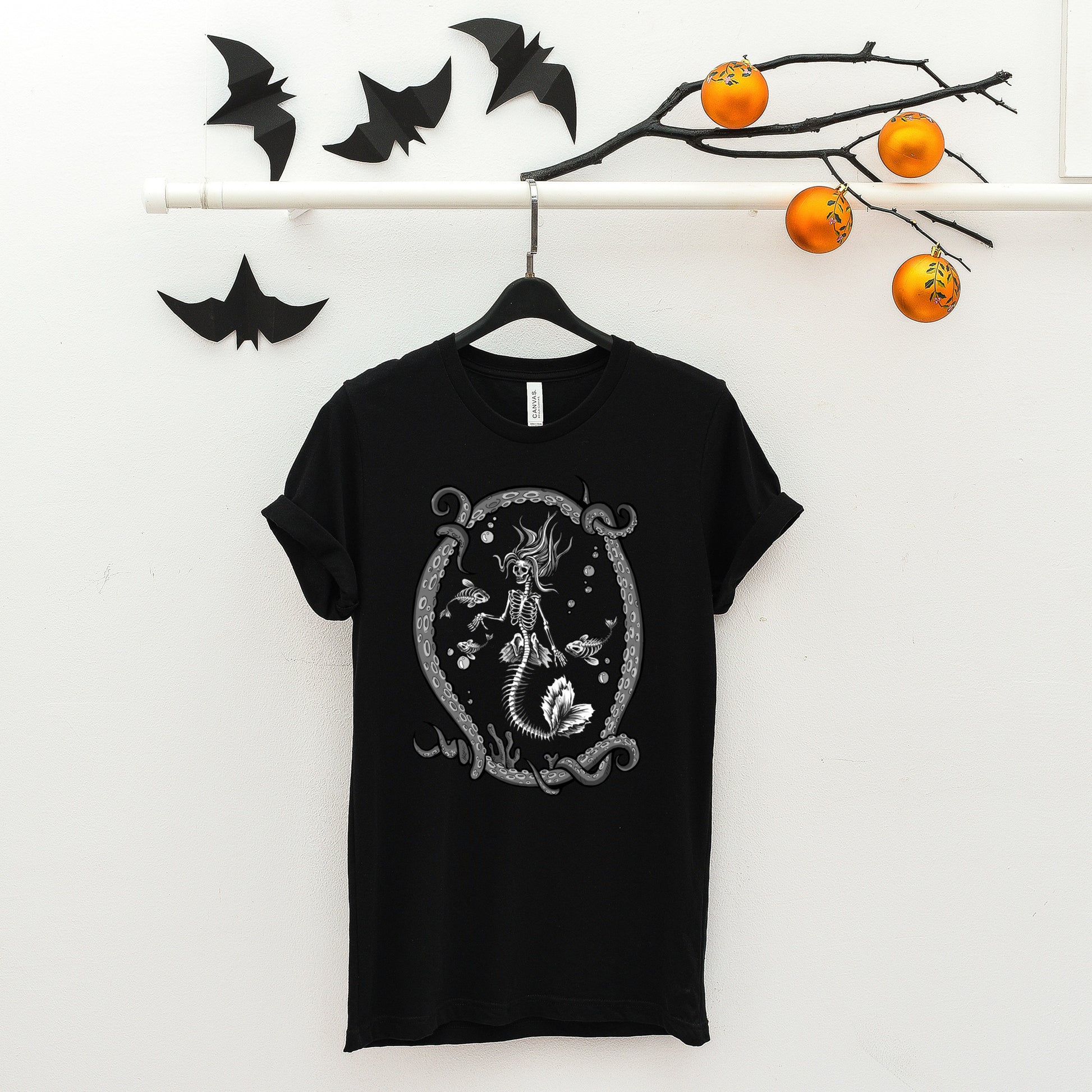 goth t-shirt with skeleton mermaid print and black skirt and boots  on white background.